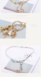 Detailed view of elastic metal leaf belt with rhinestone fish pendant and tassel