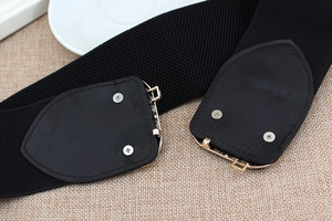 Close-up of black elastic wide waist belt featuring faux leather details and metal rivets