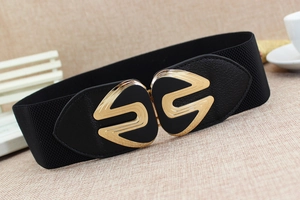 Detail of black elastic waist belt with gold geometric S-shaped buckle for women