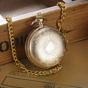 Detailed view of vintage mechanical pocket watch with floral engravings and gold chain
