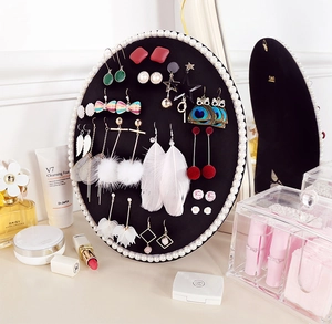 Detail of oval black velvet earring holder with white pearl trim for jewelry display