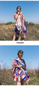 Detail of bohemian paisley shawl with colorful patterns and tassels in sunny outdoor field