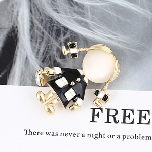 Macro shot of cute cartoon girl brooch with opal face and enamel coating detail
