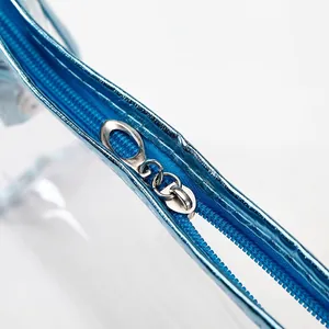 Large transparent PVC travel makeup bag with blue metallic trim and silver ring zipper