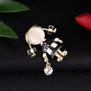 Detailed close-up of a golden girl brooch with opal stone and black-white enamel details