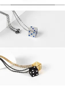 Close-up of minimalist dice pendants in silver, gold, and black with inlaid crystals