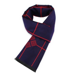 Detailed close-up of dark blue men's scarf with red geometric patterns and black tassels