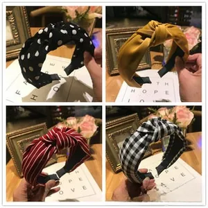 Detail view of four fabric knotted headbands in polka dot, stripes, and checkered patterns
