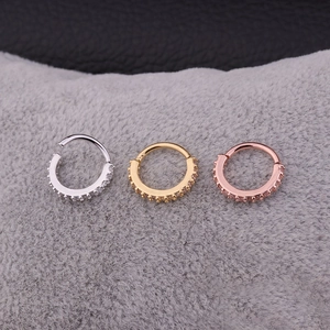 Vista macro di orecchini a cerchio con micro-pavé di zirconi in argento, oro e oro rosa