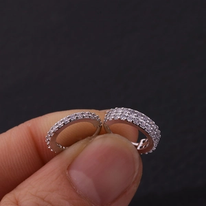 Dettaglio macro di anelli per il naso in argento con zirconi micro-pave per piercing