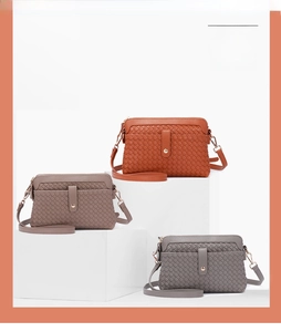 Detailed view of handmade woven shoulder bags in orange-brown, taupe and dark gray colors