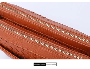Macro detail of brown woven leather bag featuring premium dual golden metal zippers