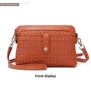 Front view of brown hand-woven crossbody bag with double pockets and gold hardware