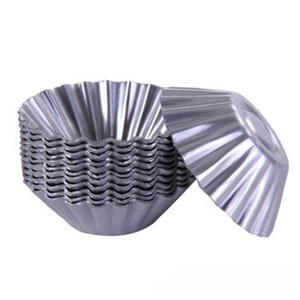 Close-up of stacked round fluted metal egg tart molds with silver metallic finish