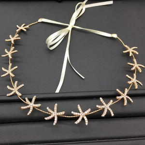Detail of gold starfish bridal headband with sparkling rhinestones and white ribbon