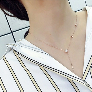 Detail of rose gold Y-necklace with heart-shaped zircon pendant and LOVE letters