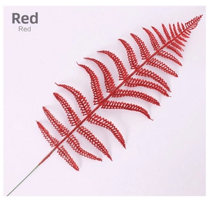 Detail of a red glittered faux fern leaf pick for festive Christmas tree decoration