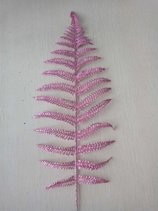 Macro shot of pink glittered artificial Persian fern leaf for Christmas tree decoration