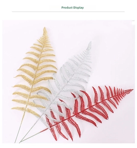 Detailed view of glittery artificial fern leaves in gold, silver, and red for Christmas decor