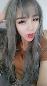 Close-up of realistic elf ears and blue wavy cosplay wig for Halloween party look