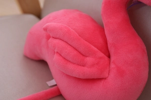 Close-up of pink flamingo plush toy showing detailed stitched feather wings and soft fabric