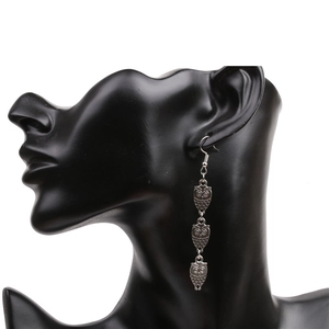 Detail of vintage silver long drop earrings featuring three stacked owl motifs on a model