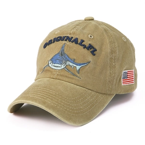 Detail of embroidered shark patch and American flag on washed khaki baseball cap
