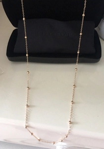 Close-up of a minimalist rose gold glasses chain with polished small beads and fine link