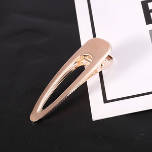 Detailed close-up of a large rose gold metal hair claw clip with smooth brushed finish