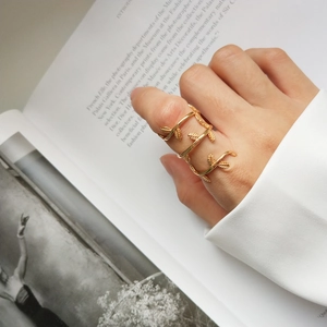 Detailed view of an adjustable gold-plated leaf wrap ring featuring a layered nature design