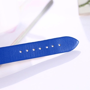 Macro detail of royal blue faux leather watch strap showing buckle adjustment holes