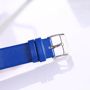 Detailed close-up of blue faux leather watch strap featuring a silver metal pin buckle
