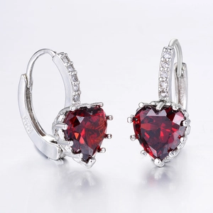 Macro shot of S925 silver heart earring with red gemstone and cubic zirconia inlay