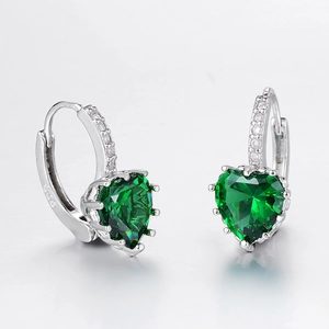 Macro shot of S925 sterling silver hoop earrings with heart-cut emerald green stones
