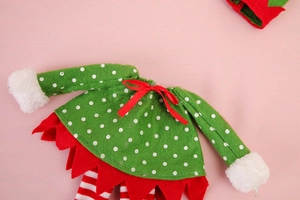 Détail du cache-bouteille de Noël elfe en feutrine verte avec bordure rouge dentelée