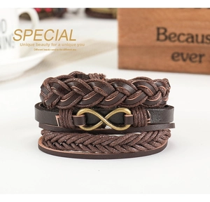 Detail of vintage infinity charm on brown leather multi-layer braided bracelet