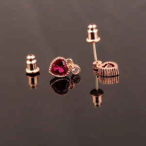 Macro shot of S925 silver heart stud earrings with red corundum in rose gold finish
