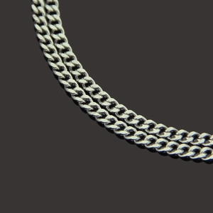 Macro shot of two silver cuban link chains showcasing detailed polished stainless steel texture