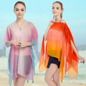 Close-up of lightweight gradient chiffon beach cover-ups in pink, blue, and orange tones