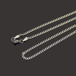 Polished silver stainless steel Cuban link necklace for men on a black reflective surface