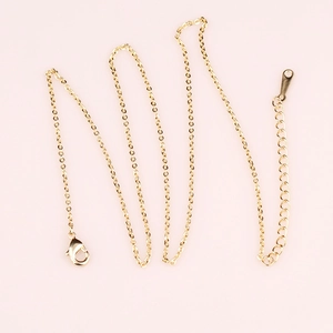 Detailed view of shiny gold-plated copper chain with lobster clasp and extension link