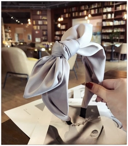 Detail of light grayish purple bow headband with textured fabric and structured design