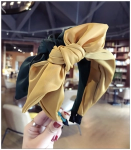 Detail of satin fabric bow headbands in mustard yellow and emerald green colors