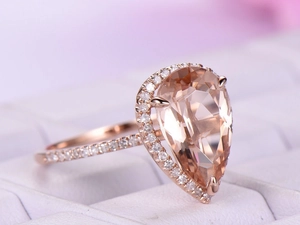 Luxury rose gold ring featuring a large pear-cut champagne gemstone with halo diamonds