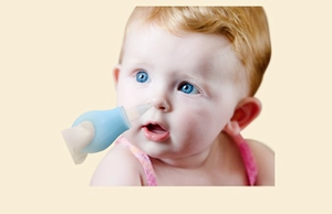 Close-up showing the manual blue silicone nasal aspirator cleaning a baby's nose