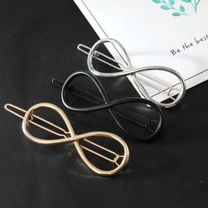 Close-up of infinity number 8 metal hair clips in gold, silver, and black finishes