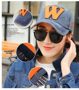 Detailed view of blue denim baseball cap featuring an orange W patch and metal buckle