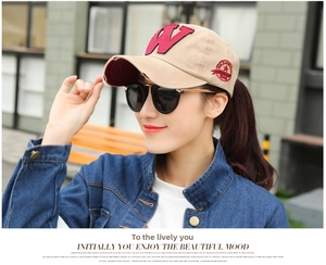 Outdoor close-up of a khaki baseball cap featuring vintage red W embroidery and side badge