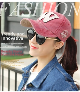 Detail view of washed red cotton baseball cap with white W embroidery and side badge