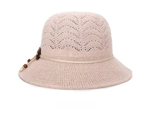 Close-up of pink knit sun hat with hollow texture, beige rope and wooden bead detail